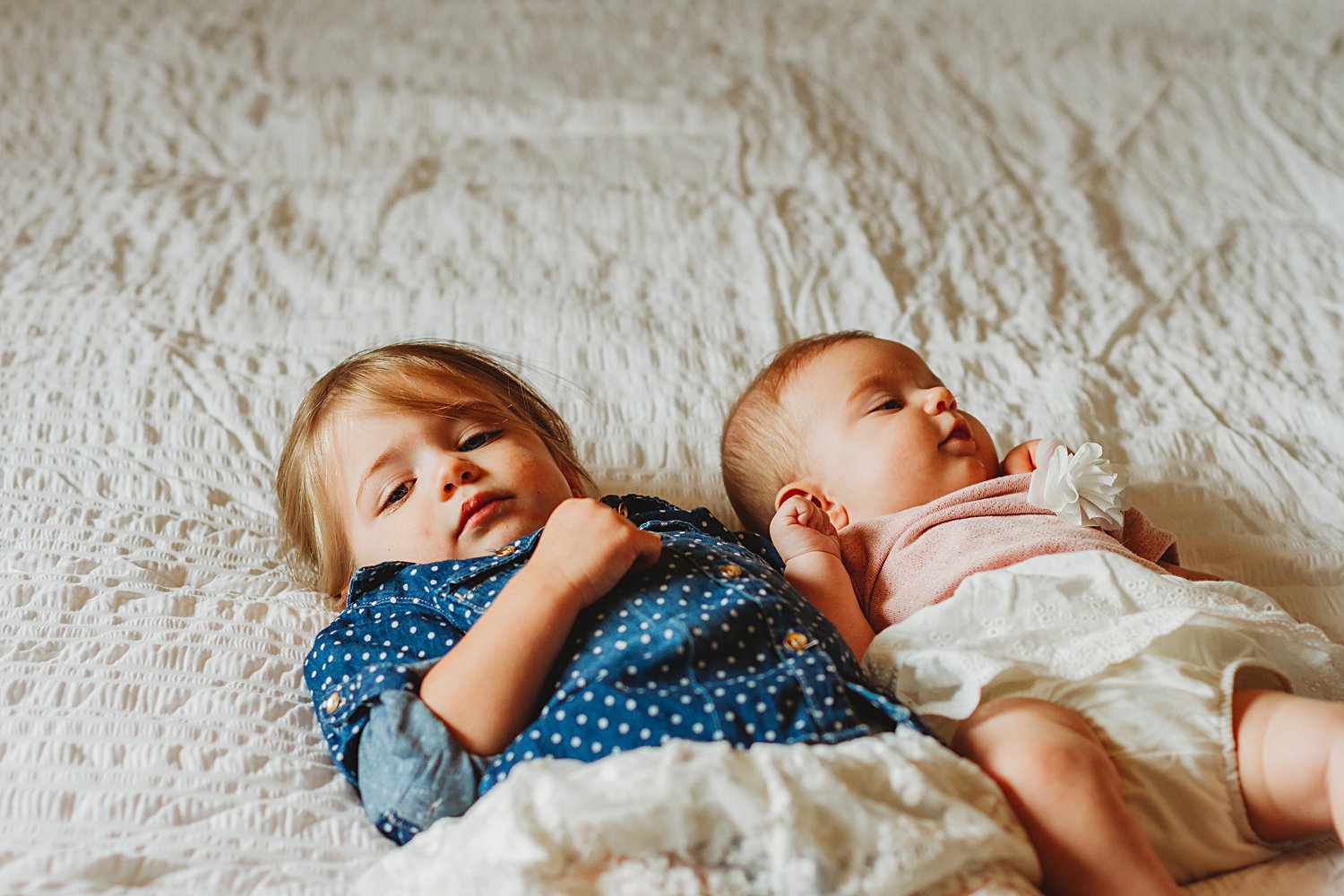 Young children laying on bed for family photos