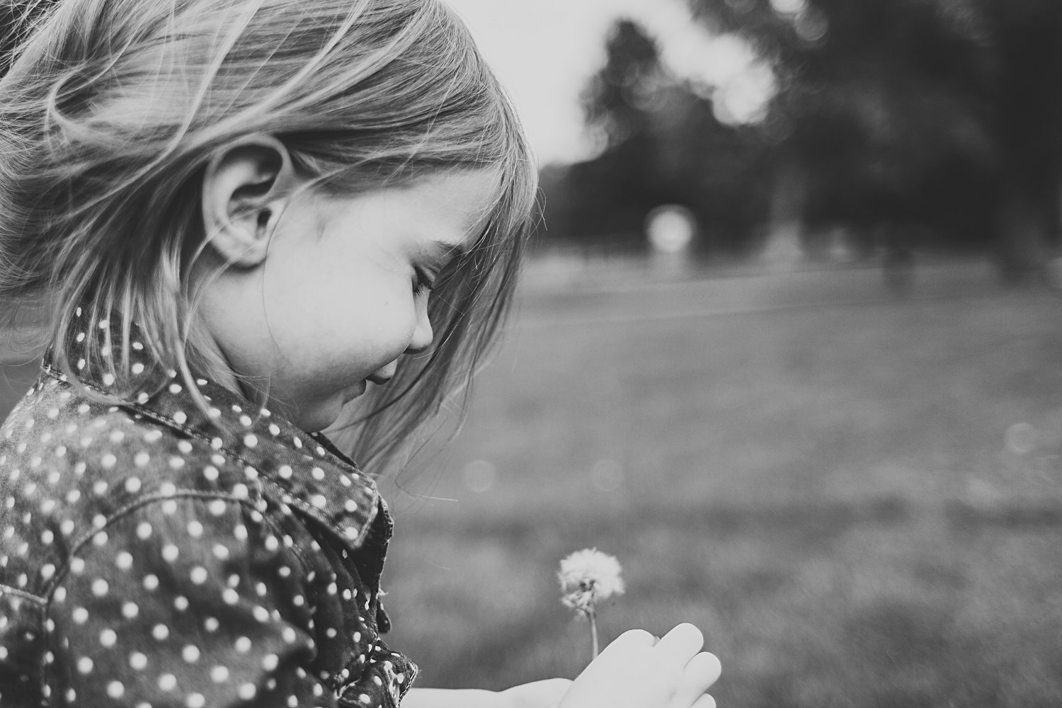 Candid portrait of young girl with dandelion