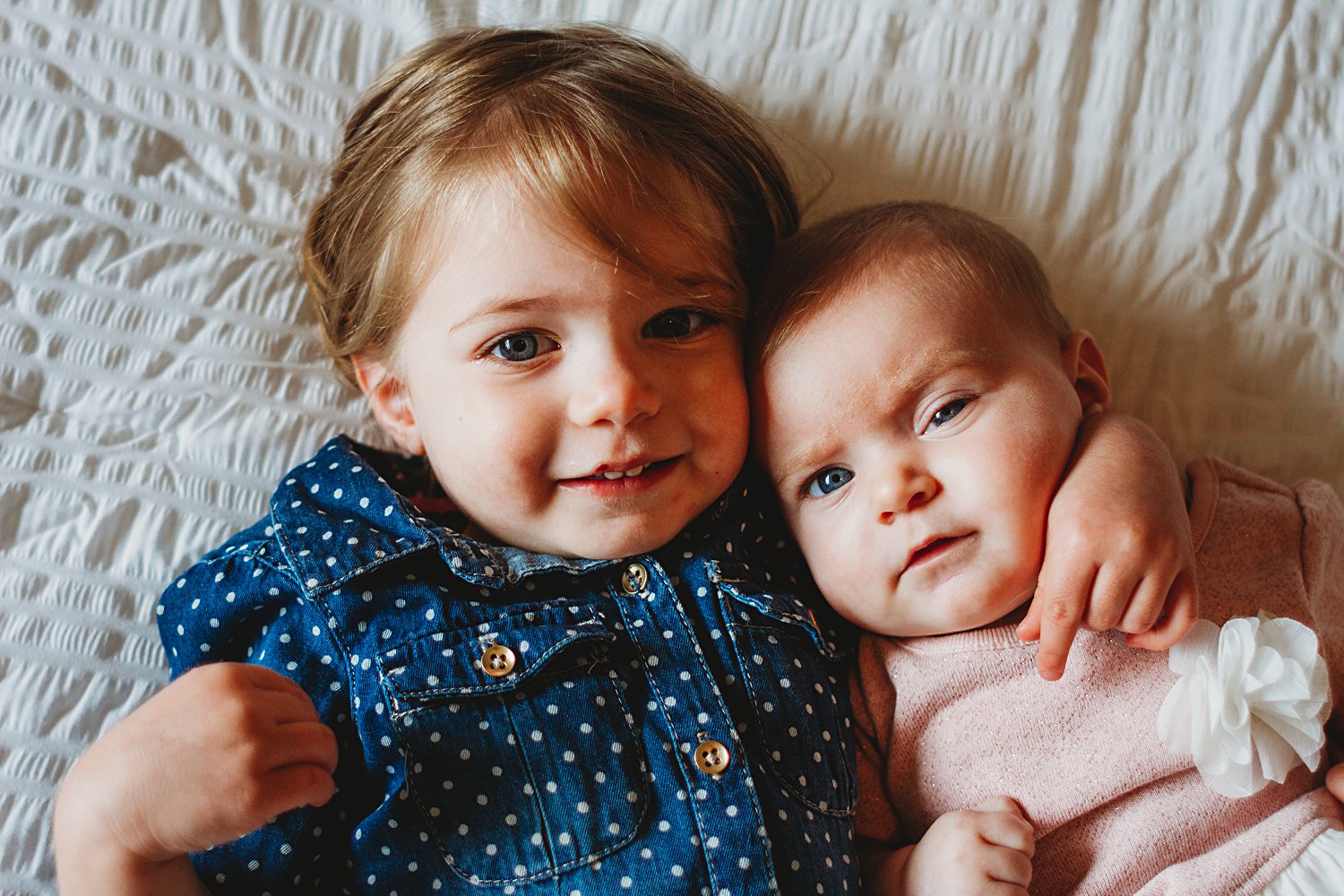 Young children laying on bed for family photos