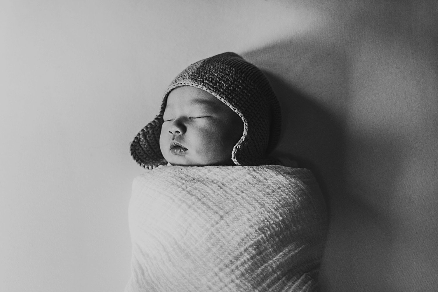 Newborn baby swaddled wearing hat