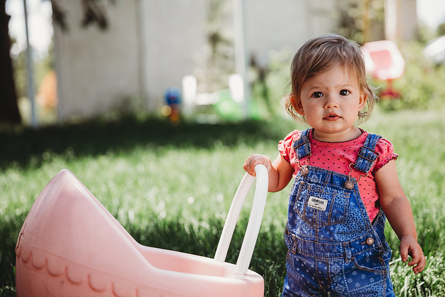 Toddler girl pushing toy stroller