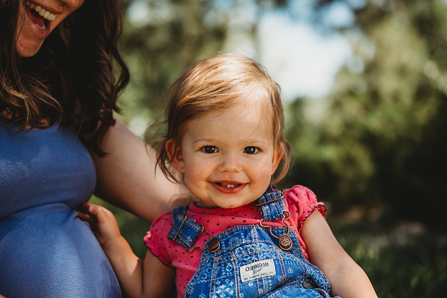 Toddler girl in pregnant mom's lap