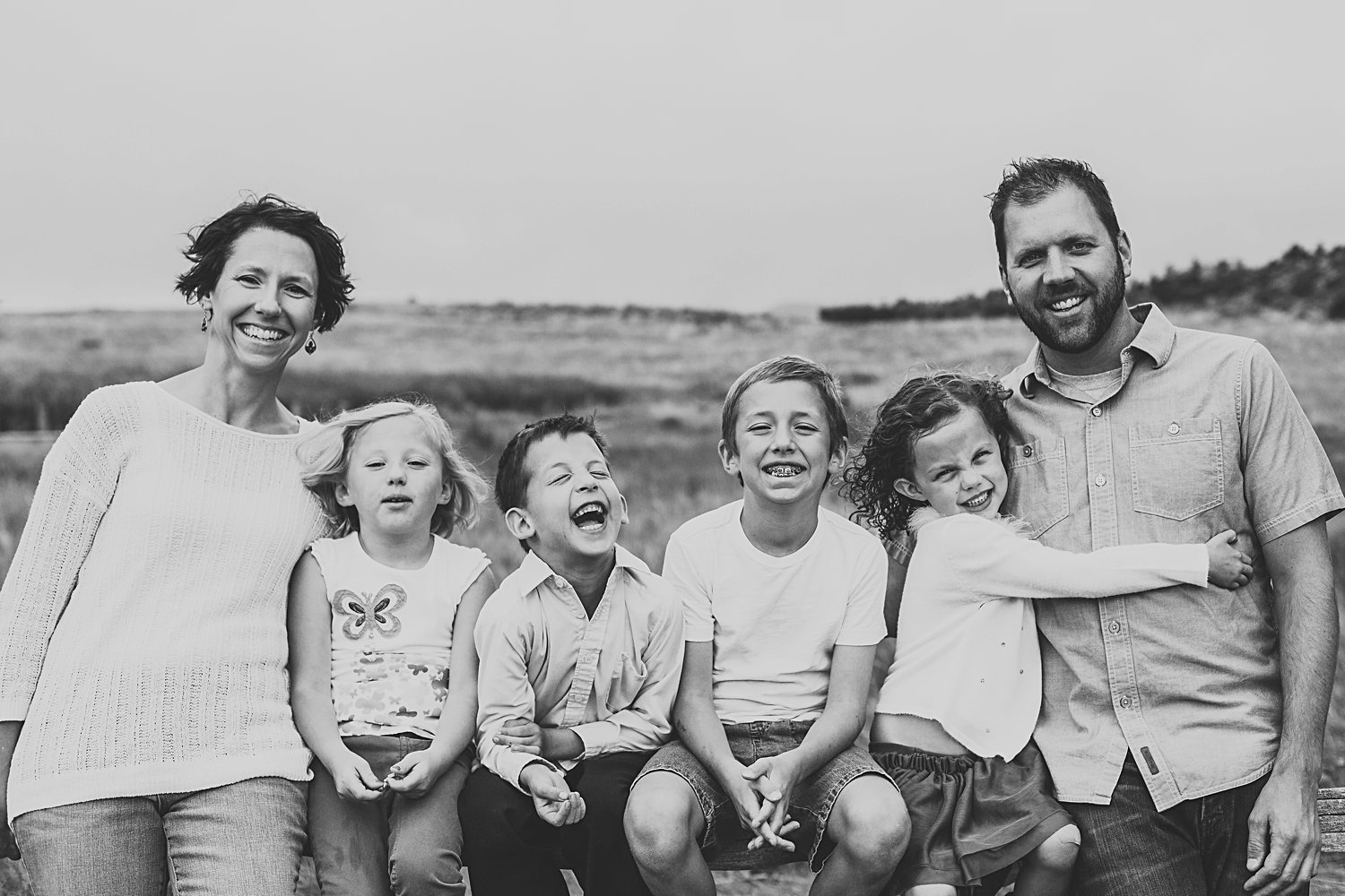 Family of six lined up on fence in Ute Valley Park