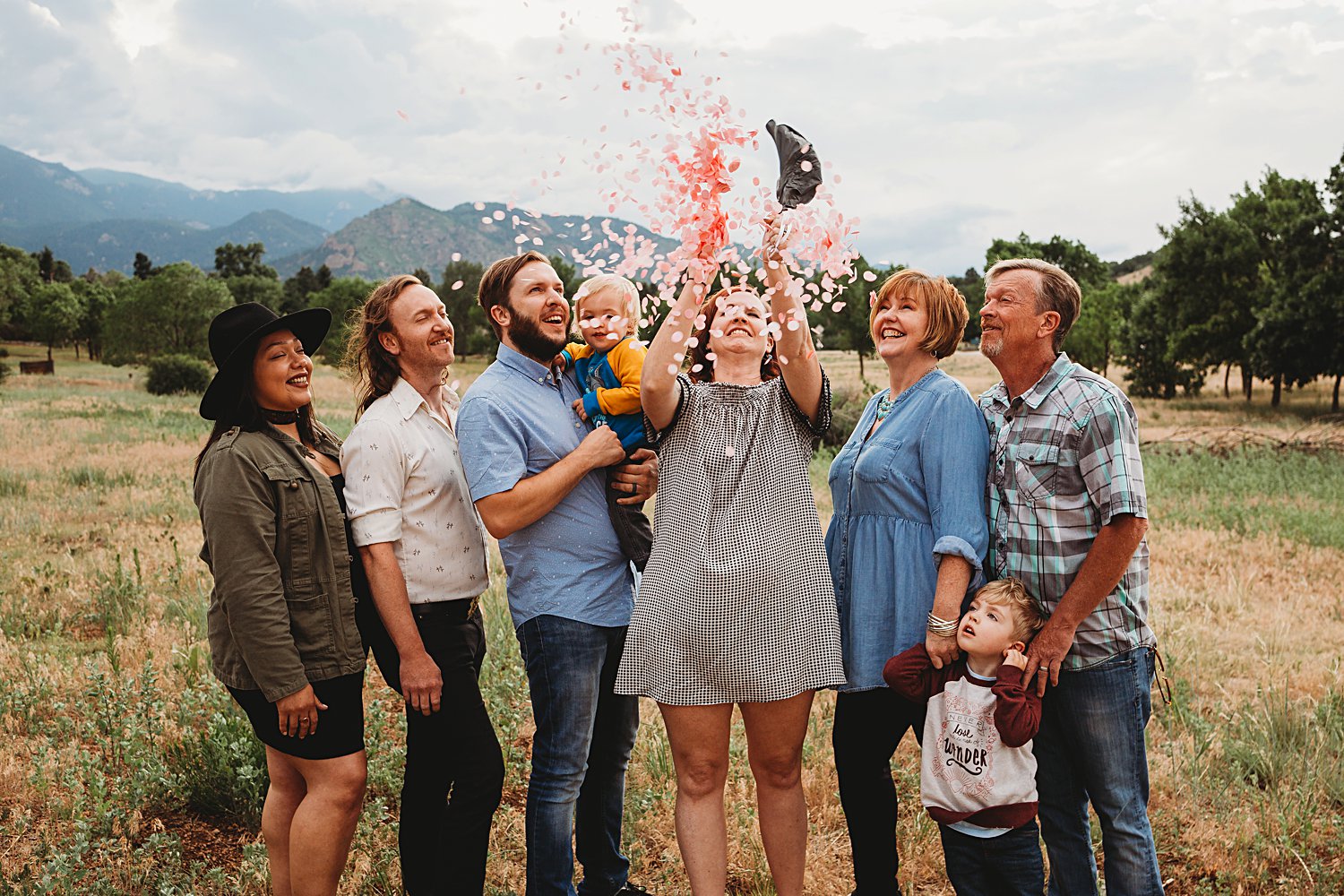 Extended family popping a gender reveal balloon