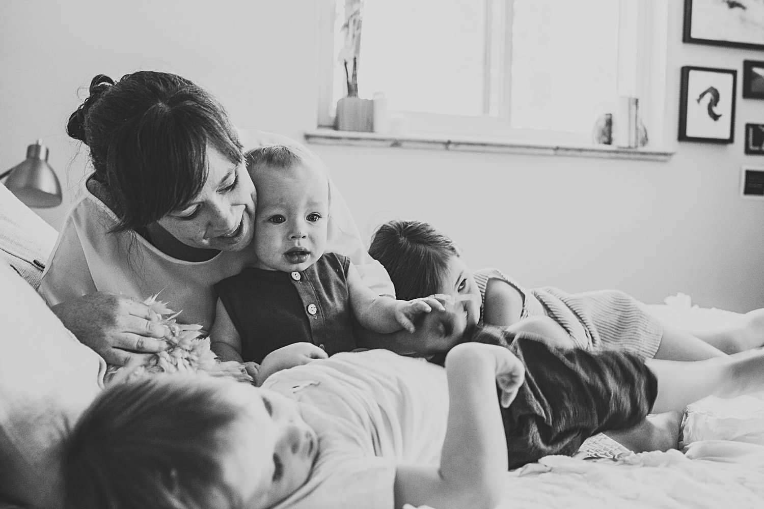 Mom cuddling with children on bed