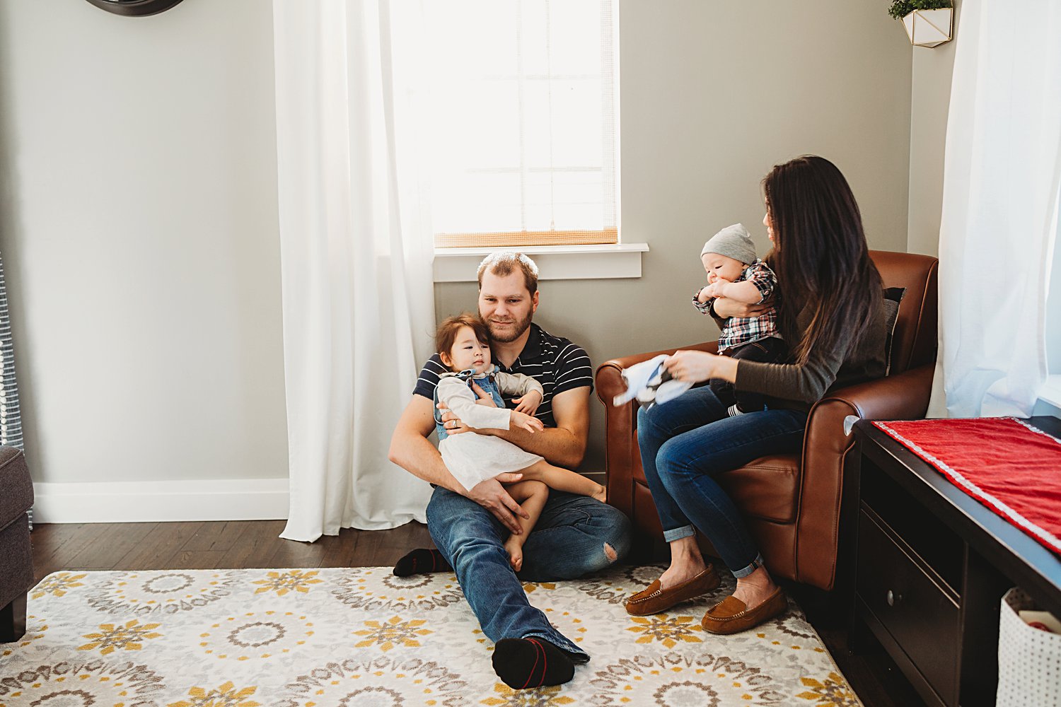 Family with two young children relaxing in family room